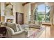 Sunlit living room features a fireplace, hardwood floors, large windows with mountain views, and neutral furniture at 5902 E Arcadia Ln, Phoenix, AZ 85018