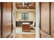 Stylish office space featuring a classic desk, comfortable chair, hardwood floors, tray ceiling, and a bright window view at 5902 E Arcadia Ln, Phoenix, AZ 85018
