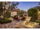 An outdoor patio area with a stone fireplace, comfortable seating, and a decorative fountain at 5902 E Arcadia Ln, Phoenix, AZ 85018