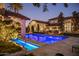 Luxury home with an inviting blue tiled swimming pool and outdoor lounge area at 5902 E Arcadia Ln, Phoenix, AZ 85018