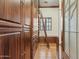 Spacious walk-in closet featuring hardwood floors, custom wood cabinetry, and a convenient rolling ladder for easy access to high shelves at 5902 E Arcadia Ln, Phoenix, AZ 85018