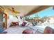 Relaxing covered patio area with ceiling fan, grill, comfortable seating, and access to the pool at 6720 W Mcrae Way, Glendale, AZ 85308
