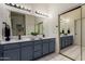 Stylish bathroom with dual sinks, and a large mirror with updated lighting fixtures at 7120 W Columbine Dr, Peoria, AZ 85381
