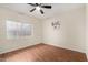 Modest bedroom featuring laminate flooring, a ceiling fan, and a window for natural lighting at 7120 W Columbine Dr, Peoria, AZ 85381