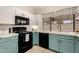 Charming kitchen featuring black appliances, white countertops, and bright teal lower cabinets at 7120 W Columbine Dr, Peoria, AZ 85381