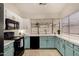 Bright kitchen featuring black appliances, white countertops, and light teal lower cabinets at 7120 W Columbine Dr, Peoria, AZ 85381