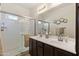 Bathroom with double sinks, framed mirror, and walk-in shower with glass door at 7726 E Baseline Rd # 156, Mesa, AZ 85209