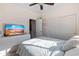 Bright bedroom featuring a ceiling fan, TV, and sliding closet doors at 7726 E Baseline Rd # 156, Mesa, AZ 85209