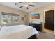 Bright bedroom featuring a queen bed, dresser, ceiling fan, and a picturesque window view at 7726 E Baseline Rd # 156, Mesa, AZ 85209