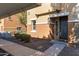 Condo front entry featuring neutral stucco, dark door, trimmed landscaping, and visible unit number '16' at 7726 E Baseline Rd # 156, Mesa, AZ 85209