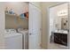 Bright laundry room with washer and dryer, storage shelves, and access to a bathroom at 7726 E Baseline Rd # 156, Mesa, AZ 85209