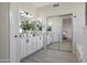 Bathroom with double sink vanity, framed mirrors, and tiled flooring leading to the bath at 7908 W Harmony Ln, Peoria, AZ 85382