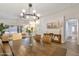Formal dining room with wooden table, elegant lighting, and neutral décor at 7908 W Harmony Ln, Peoria, AZ 85382