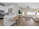 Open-concept layout: kitchen with bar seating flows into living room with fireplace and natural light at 7908 W Harmony Ln, Peoria, AZ 85382