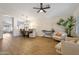 Open-concept living area with hardwood floors, neutral tones, and plenty of natural light, open to a dining area at 7908 W Harmony Ln, Peoria, AZ 85382
