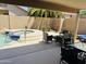 Covered patio with outdoor seating overlooking the pool and spa area in the backyard at 7908 W Harmony Ln, Peoria, AZ 85382