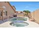 Relaxing backyard pool and spa with desert landscaping and hardscape features surrounded by block wall at 7908 W Harmony Ln, Peoria, AZ 85382