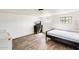 Well-lit bedroom including bed frame, dresser, small TV, and wood-look flooring at 8218 S 7Th St # 163, Phoenix, AZ 85042