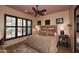 Bedroom features dark wood windows with shutters, ceiling fan and a comfortable bed at 8406 E Calle Buena Vis, Scottsdale, AZ 85255