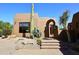 Beautiful home exterior with desert landscaping, an arched entry, and a red front door at 8406 E Calle Buena Vis, Scottsdale, AZ 85255