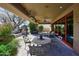 Covered patio features a ceiling fan, heaters, stone table, and access to backyard at 8406 E Calle Buena Vis, Scottsdale, AZ 85255