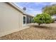 Side view of a home featuring low maintenance gravel, a screened in porch, and a well manicured tree at 890 E Tee St, San Tan Valley, AZ 85140