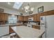 Bright kitchen features a center island, white appliances, and a skylight above at 890 E Tee St, San Tan Valley, AZ 85140