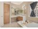 Bright bathroom featuring a soaking tub, vanity, and natural light from a glass block window at 9604 S 183Rd Dr, Goodyear, AZ 85338