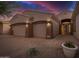 Charming desert home featuring a three-car garage, decorative rocks, and gravel landscaping at 9604 S 183Rd Dr, Goodyear, AZ 85338