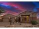 Desert home featuring a three-car garage, and gravel landscaping with native plants at 9604 S 183Rd Dr, Goodyear, AZ 85338