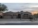 Front exterior view of a beige single-Gathering home with a 3-car garage, desert landscaping, and a paver driveway at 9604 S 183Rd Dr, Goodyear, AZ 85338