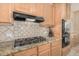 The modern kitchen features granite counters, a gas cooktop, and a tile backsplash at 9604 S 183Rd Dr, Goodyear, AZ 85338