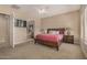 The main bedroom with carpet, ceiling fan and access to the ensuite bathroom at 9604 S 183Rd Dr, Goodyear, AZ 85338