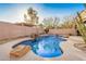 In-ground pool with rock features, desert landscaping, water feature and rock features in a private backyard with block wall at 9604 S 183Rd Dr, Goodyear, AZ 85338