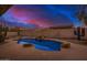 Sparkling pool with rock features, surrounded by desert landscaping creating a private and serene backyard oasis at 9604 S 183Rd Dr, Goodyear, AZ 85338