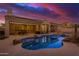 Inviting backyard pool with rock features, covered patio, and seating under a sunset sky at 9604 S 183Rd Dr, Goodyear, AZ 85338