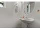 Powder room featuring sleek pedestal sink and decorative mirror with neutral paint at 10162 E Theorem Dr, Mesa, AZ 85212