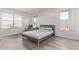 Minimalist bedroom with plank floors, bright windows and a comfortable recliner chair at 10162 E Theorem Dr, Mesa, AZ 85212