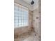 Shower featuring neutral tile, glass block window, and a shower head at 1023 E Rosemonte Dr, Phoenix, AZ 85024