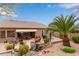 Beautifully landscaped backyard with a covered patio, lush greenery, and a charming water feature at 10796 E Betony Dr, Scottsdale, AZ 85255
