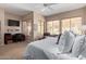 Bright bedroom with large windows, carpet floors, and a dedicated desk area with TV at 10796 E Betony Dr, Scottsdale, AZ 85255