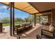 Relaxing covered patio with comfortable seating and serene views of the lush green community lawn at 10796 E Betony Dr, Scottsdale, AZ 85255