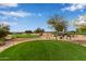 Lush green golf course with beautiful blue skies, mature trees, and golf carts in the distance at 10796 E Betony Dr, Scottsdale, AZ 85255