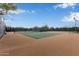 Well-maintained tennis court with fencing and lighting in a green community at 10796 E Betony Dr, Scottsdale, AZ 85255