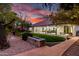 A manicured backyard featuring a covered patio, green lawn, and verdant perimeter landscaping at 1109 W Las Palmaritas Dr, Phoenix, AZ 85021