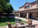 A spacious backyard features a covered patio, lush lawn, and comfortable seating for outdoor enjoyment and entertainment at 11219 N 165Th Ave, Surprise, AZ 85388