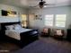 A serene bedroom with ceiling fan, chairs, a dark-wood bed, and natural light at 11219 N 165Th Ave, Surprise, AZ 85388
