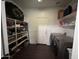 A laundry room with a washer and dryer, shelving, and wood floors at 11219 N 165Th Ave, Surprise, AZ 85388