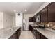 Modern kitchen with granite countertops, stainless steel appliances, an island, and dark wood cabinets at 1178 E Tyler Ln, Casa Grande, AZ 85122