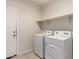Bright laundry room features a modern washer, dryer, and convenient shelving for storage at 1178 E Tyler Ln, Casa Grande, AZ 85122